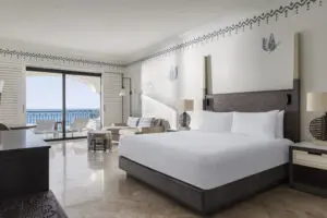 imagen de una habitación con cama doble y balcón con vistas al mar