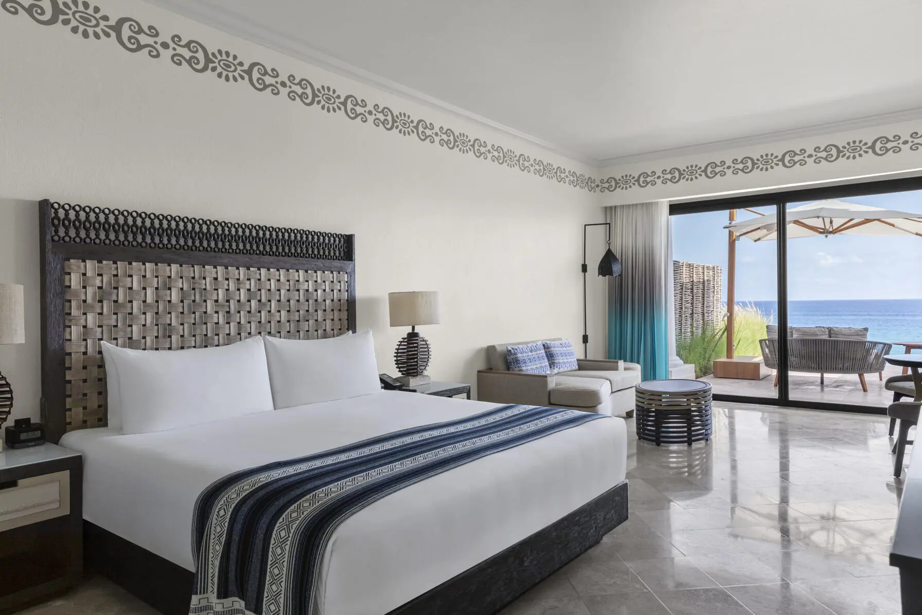 imagen de la habitación con cama doble sala de estar con balcón con vista al mar