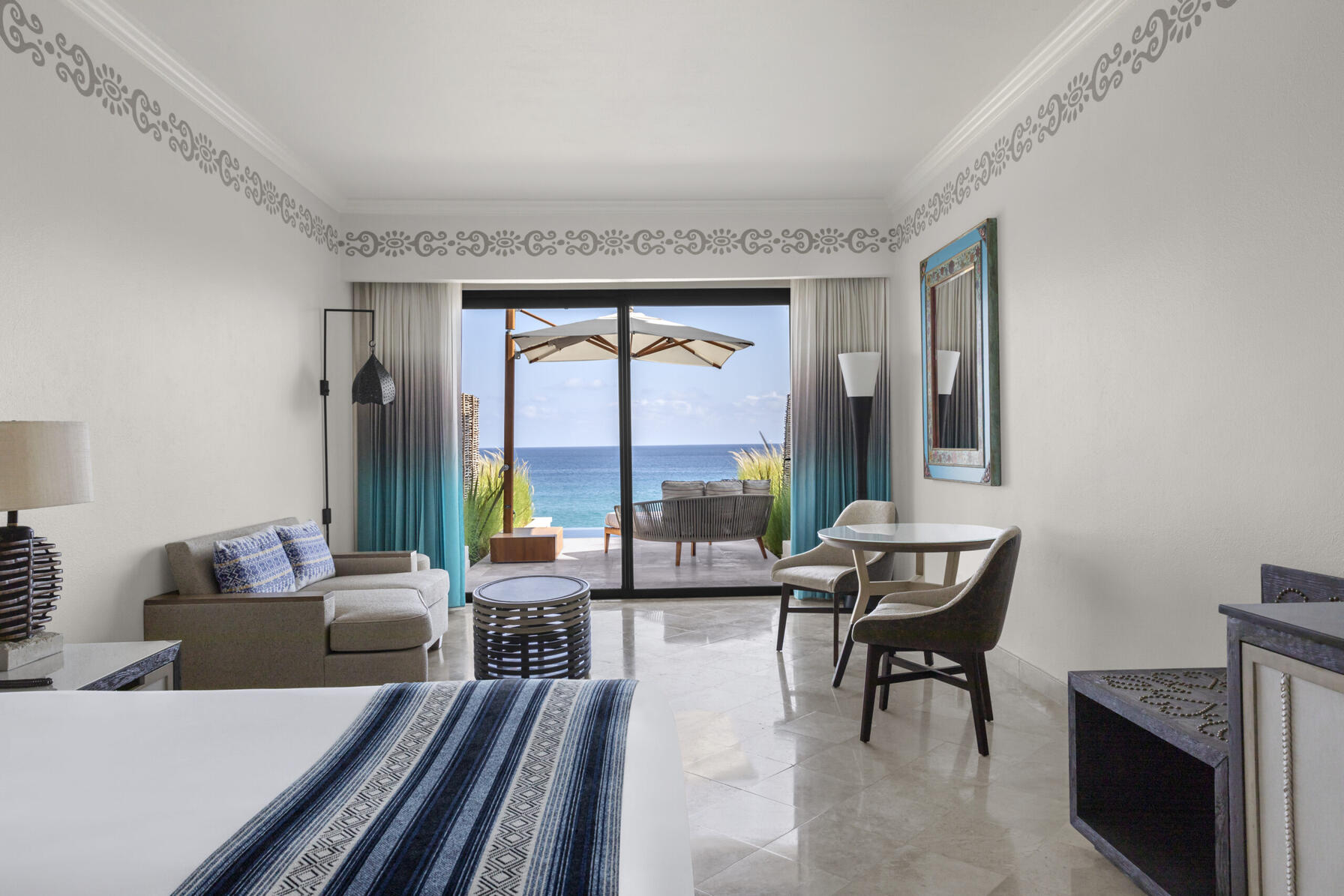 imagen de la habitación con zona de estar y balcón con vistas al mar