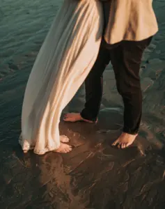 picture of legs of bride and groom on sea beach