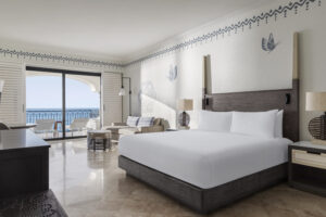 imagen de un dormitorio con una cama doble y vista al mar desde el balcón