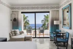 imagen de una sala de estar en una habitación con vista al mar desde el balcón