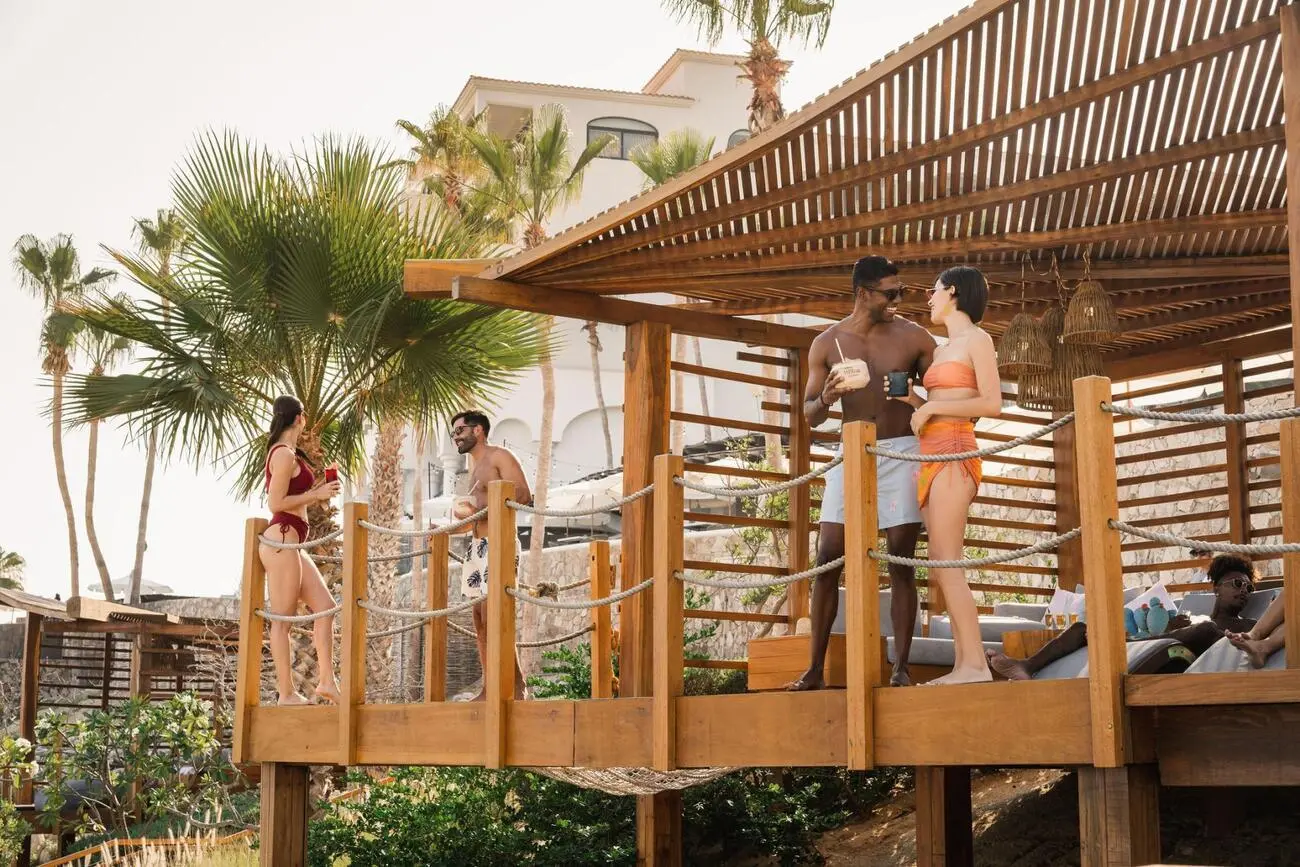 foto de personas de pie en el área del balcón de una cabaña cerca de la piscina