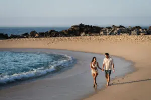 picture of two people walking on the sea beach
