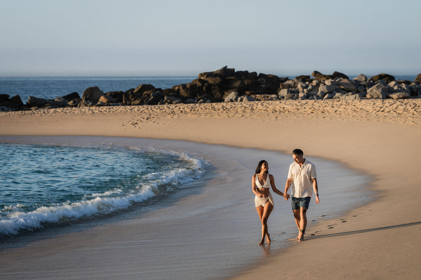picture of two people walking on the sea beach