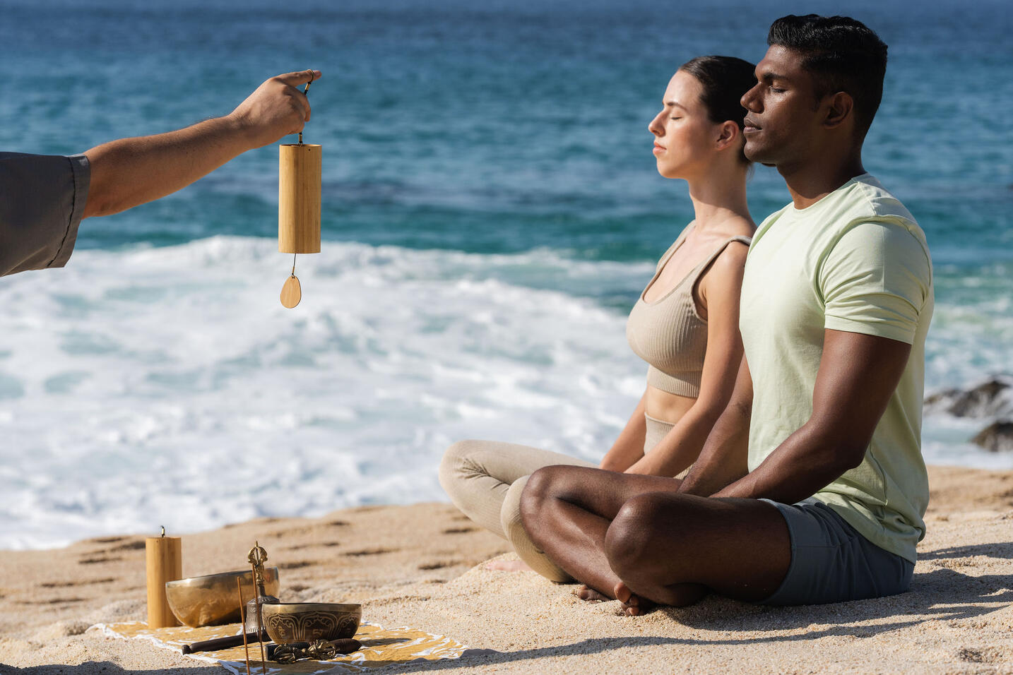 foto de dos personas haciendo meditación en la playa del mar