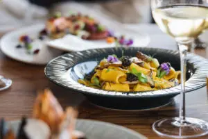 picture of pasta in a plate and white wine in a glass