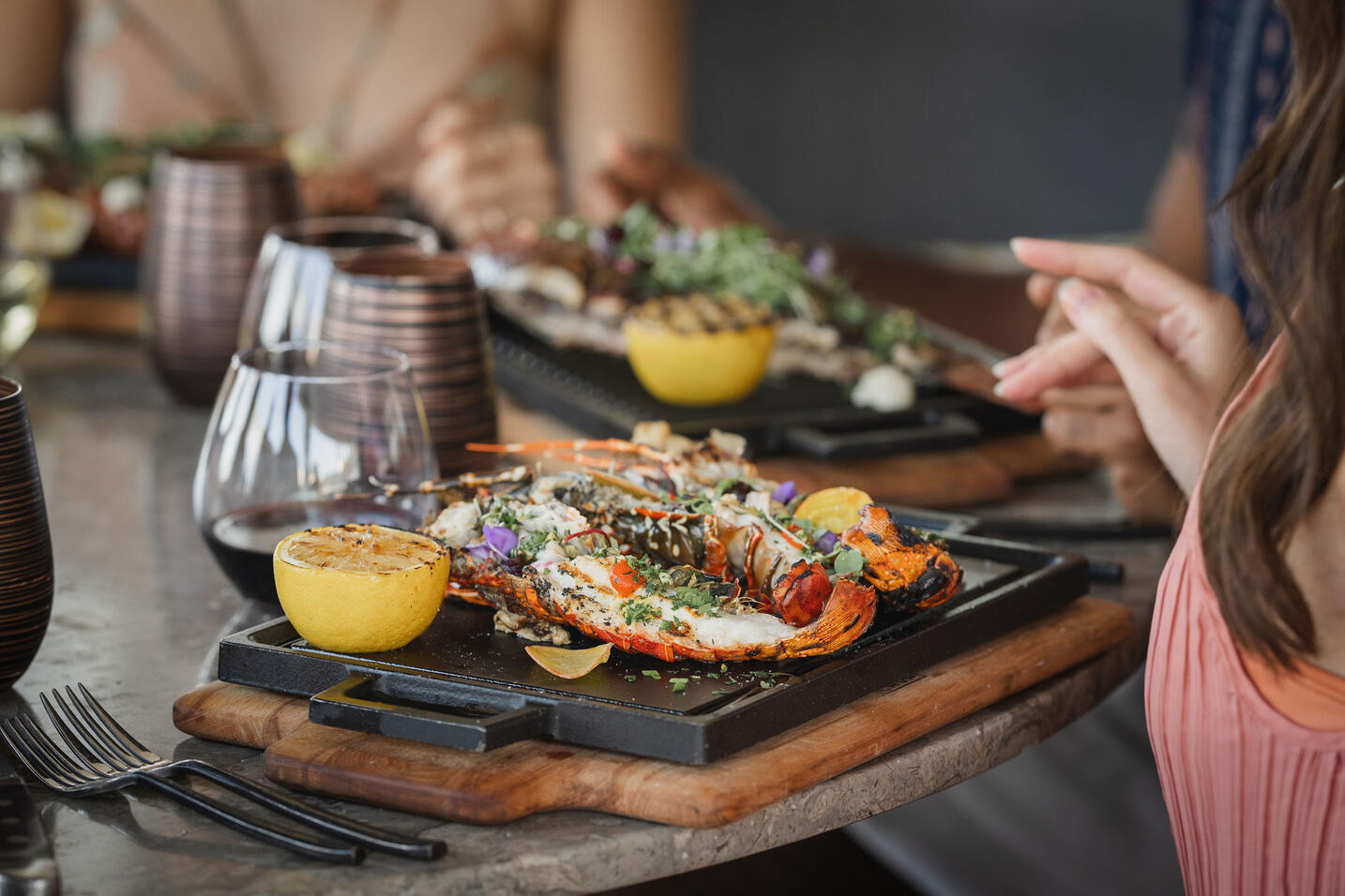 picture of a dish on platter on a table with hands in frame