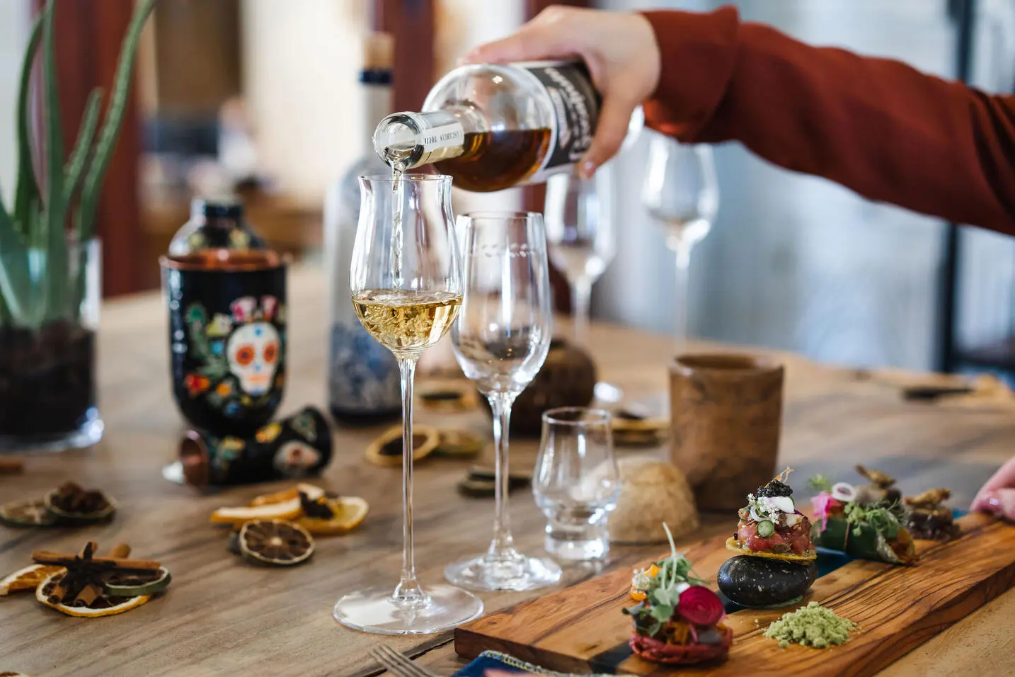 picture of a table with food items and wine being poured in the glass