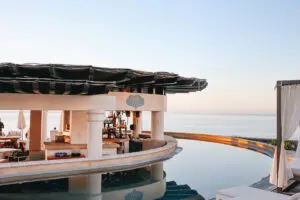 picture of a restaurant and bar in between the pool of a hotel