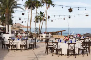 imagen de un restaurante vacío con vidrio en la mesa y sillas de cojines y vista al mar
